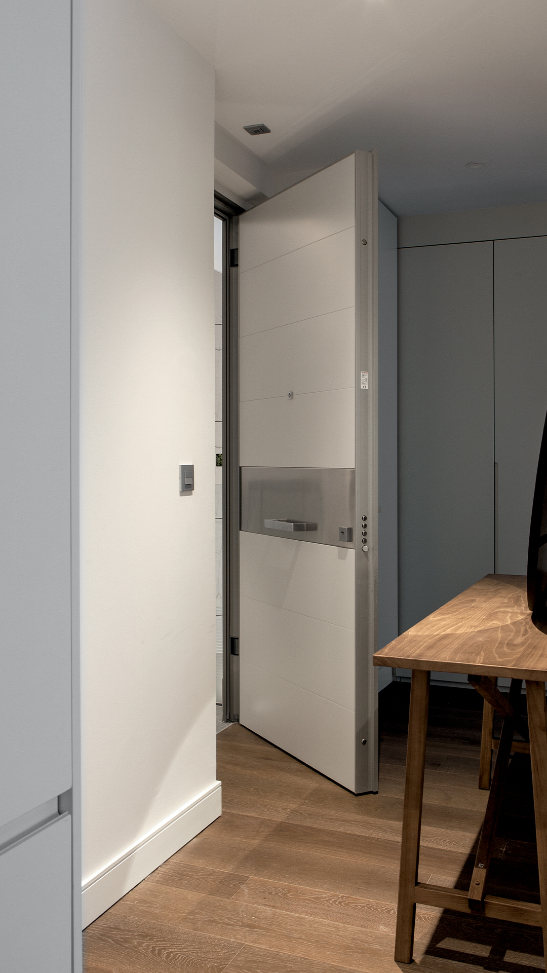 Produktfoto einer Oikos Tekno Außendrehtür mit verdeckten Bändern und gebürsteter Stahl-Aluminiumoberfläche, realisiert von der Krenzer GmbH als zertifiziertem Oikos-Vertriebspartner
